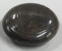 An engraved silver pill box with hinged lid.
