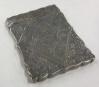 A Victorian silver card case engraved with flowers.