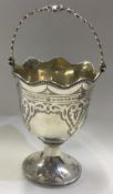 A large Victorian silver swing handled basket with engraved and hand chased decoration.