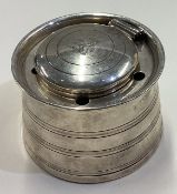 A Victorian silver inkwell with central armorial.