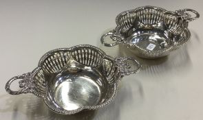 A pair of silver dishes with swag handles and pierced decoration. Birmingham 1909.