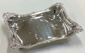 TIFFANY & CO: A chased silver dish on four feet. Circa 1900.