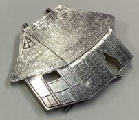 A Chinese silver menu holder in the form of a thatched cottage.