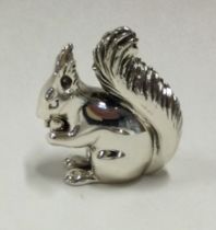A silver figure of a squirrel.