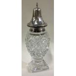 A silver and glass sugar caster on square base.