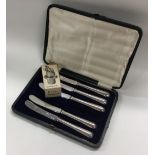 A silver plated drip stopper together with five cased silver table knives.