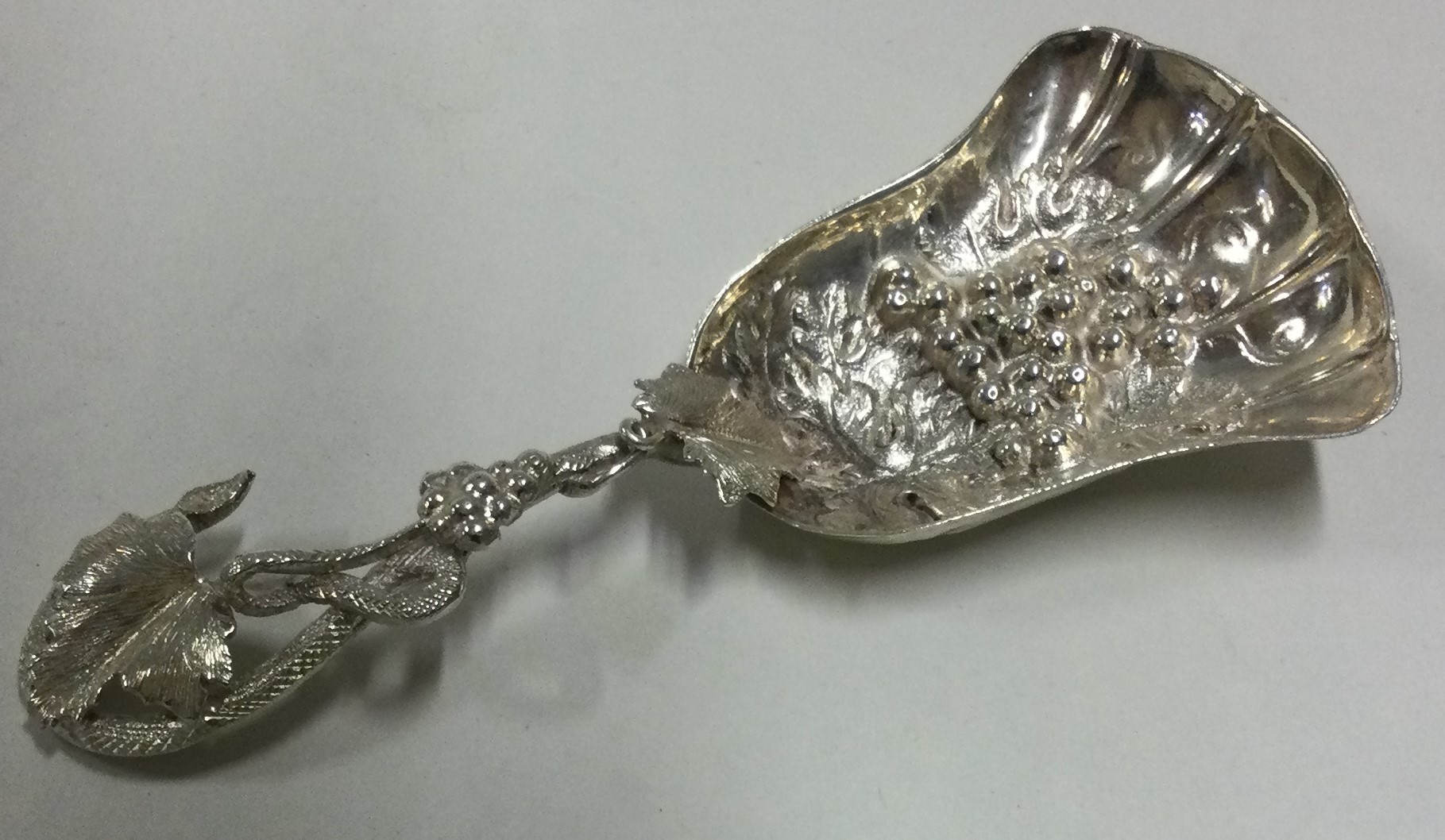 A Victorian cast silver caddy spoon with fluted bowl.