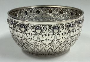 A heavy Victorian silver sugar bowl with textured decoration.