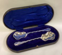 A cased pair of silver serving spoons.