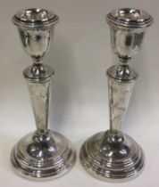 A pair of silver candlesticks of typical form.