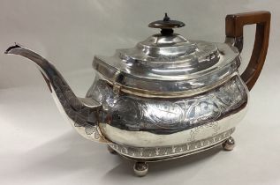 A George III silver teapot engraved with eagles and leaf decoration.