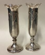 A pair of silver vases.