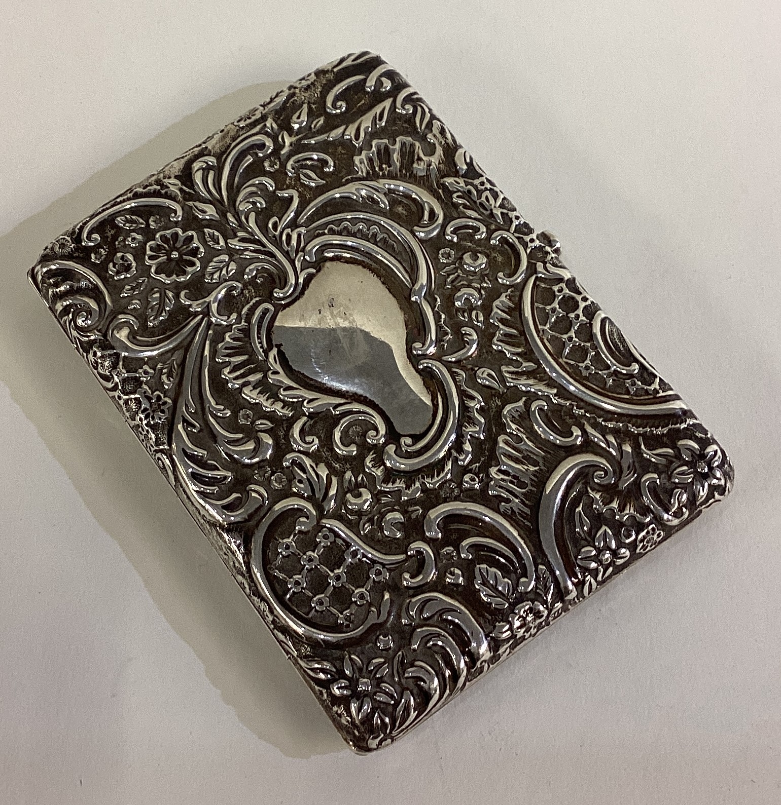 A chased Victorian silver card case.