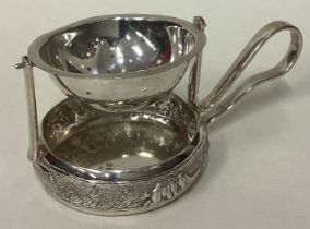 A rare Indian silver tea strainer on stand with chased decoration.