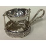 A rare Indian silver tea strainer on stand with chased decoration.