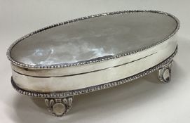 A large jewellery box with hinged lid on feet.