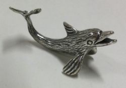 A silver figure of a dolphin.