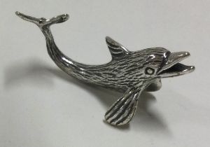 A silver figure of a dolphin.