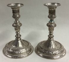 A pair of early Queen Anne cast silver candlesticks.