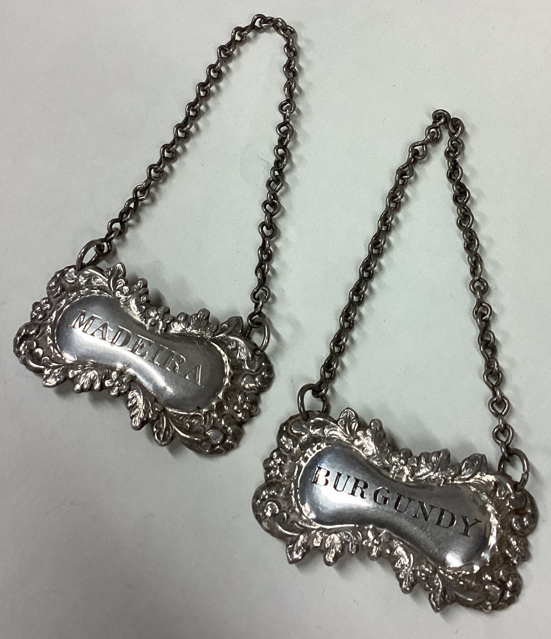 A pair of Victorian silver wine labels for 'Madeira' and 'Burgundy'.