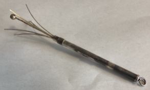 A small silver swizzle stick.