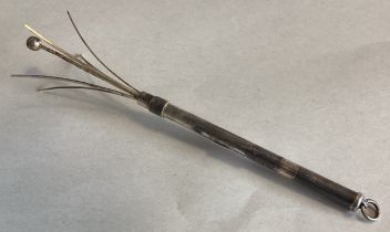 A small silver swizzle stick.