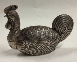 A heavy silver pill box in the form of a cockerel.