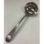 A George III silver bottom marked sauce ladle with crested and beaded decoration.