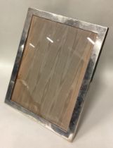 A large American silver picture frame with glass insert.