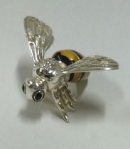 A silver and enamelled figure of a bee.