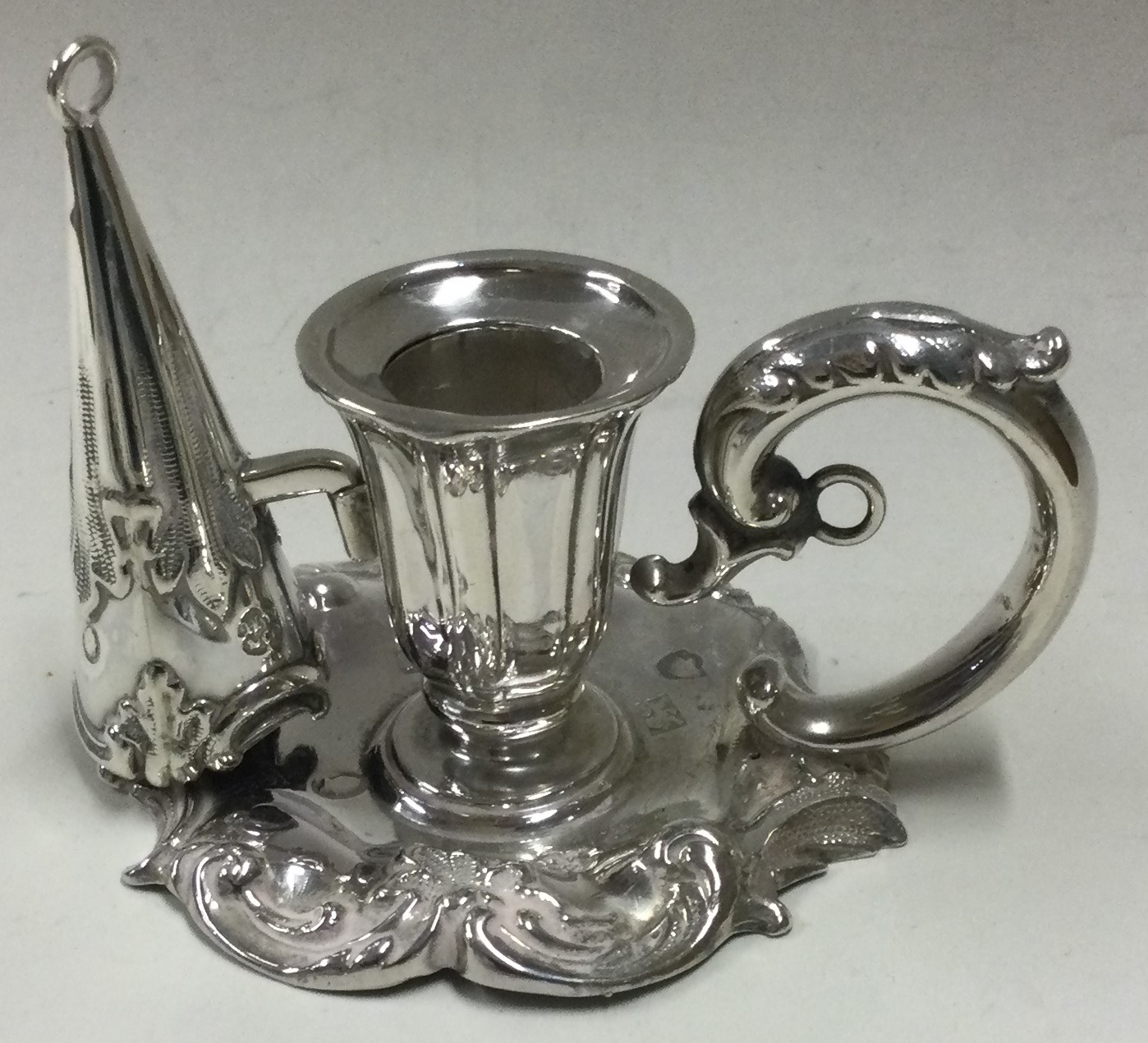 A small Victorian silver chamberstick with matching snuffer.