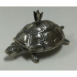 A silver pill box with hinged lid in the form of a tortoise.