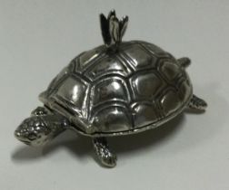 A silver pill box with hinged lid in the form of a tortoise.