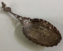 A silver caddy spoon with figural decoration.