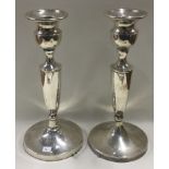 A pair of tall silver candlesticks.