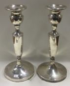 A pair of tall silver candlesticks.