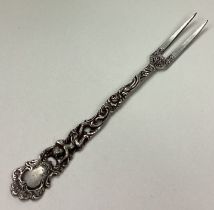 A Continental silver fork with pierced cherub decoration.