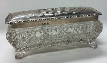 A George V silver and cut glass box decorated with cherubs.