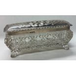 A George V silver and cut glass box decorated with cherubs.