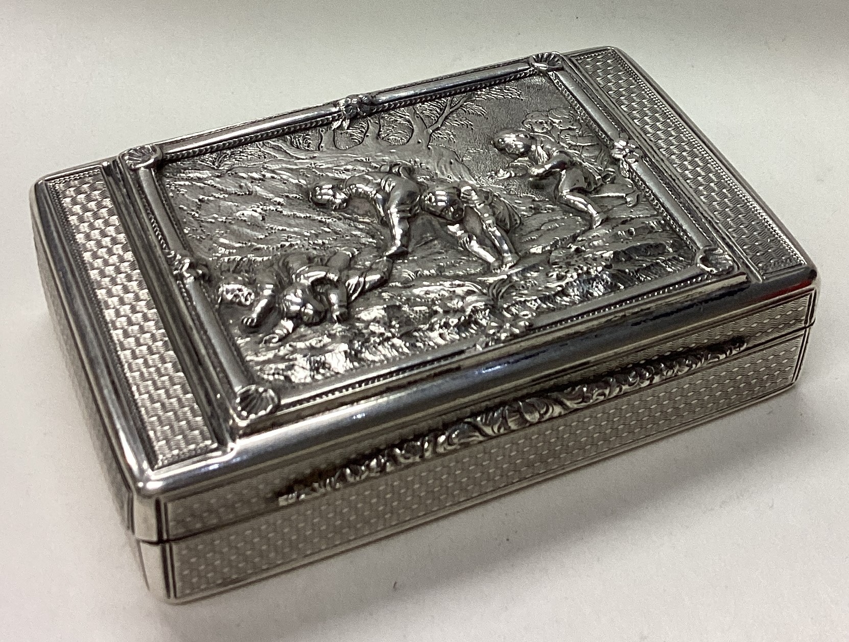 A rare Victorian silver snuff box cast with figural scenes and trees.
