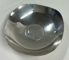 A small silver pin dish with coin inset.
