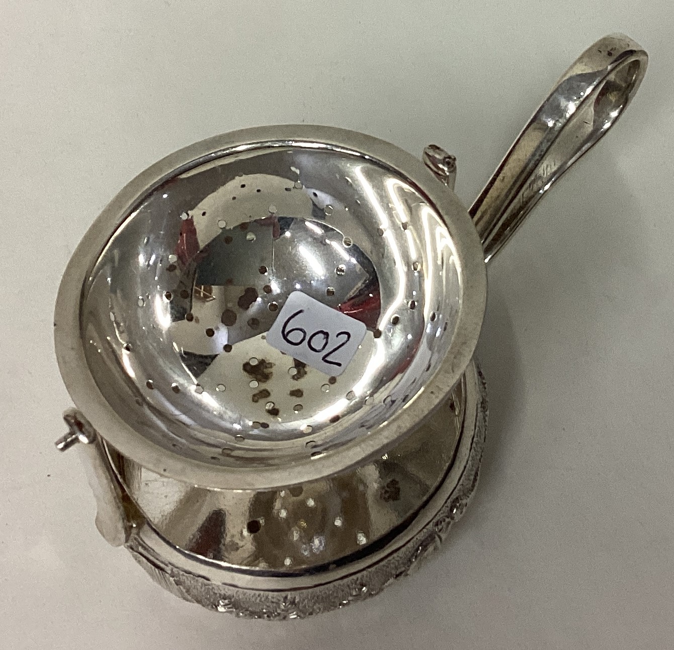 A rare Indian silver tea strainer on stand with chased decoration. - Image 2 of 3