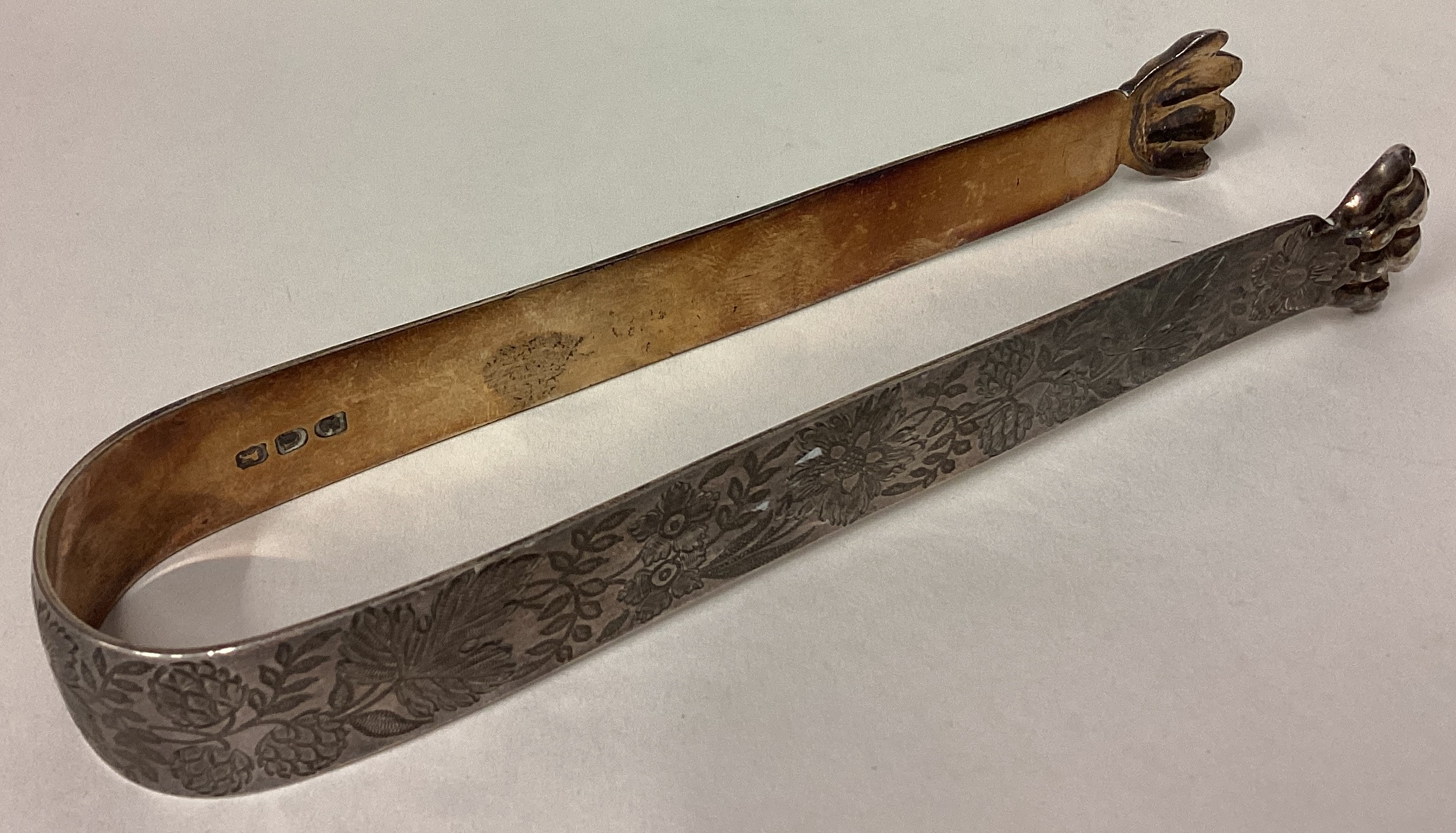 A rare pair of George III silver claw ice tongs engraved with floral decoration.