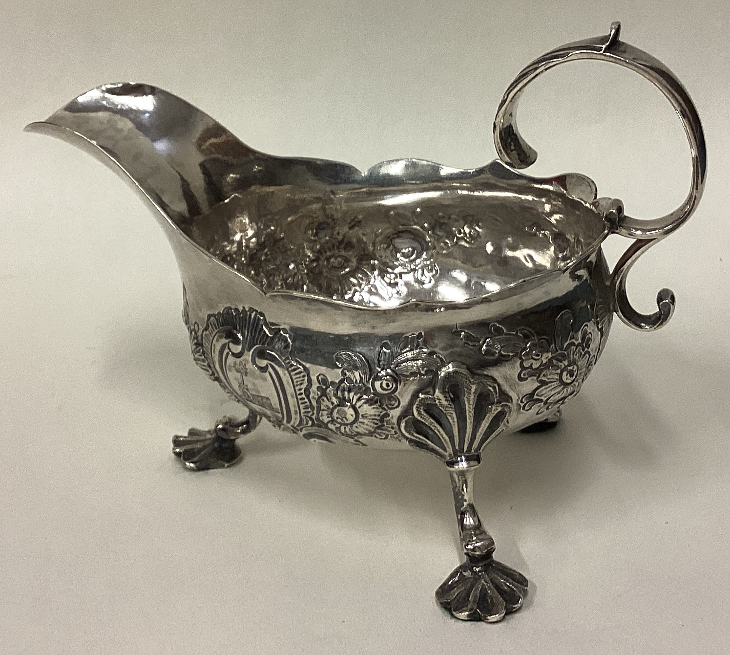 An 18th Century George III silver sauce boat with chased decoration.