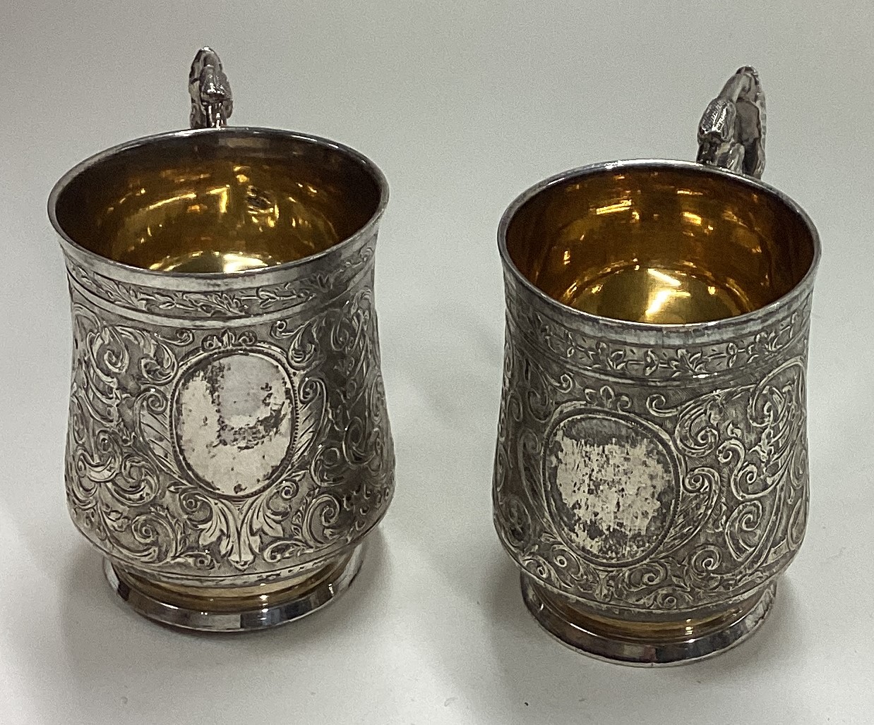 A pair of chased French silver shot cups with handles.