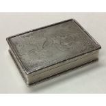 A cast silver snuff box engraved with birds and trees.