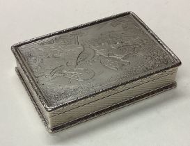 A cast silver snuff box engraved with birds and trees.