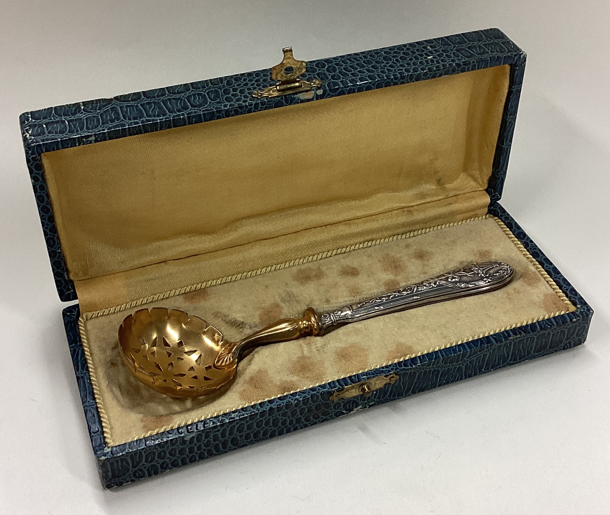 A cased French silver sifter spoon with pierced decoration.