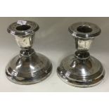 A pair of circular silver piano candlesticks.