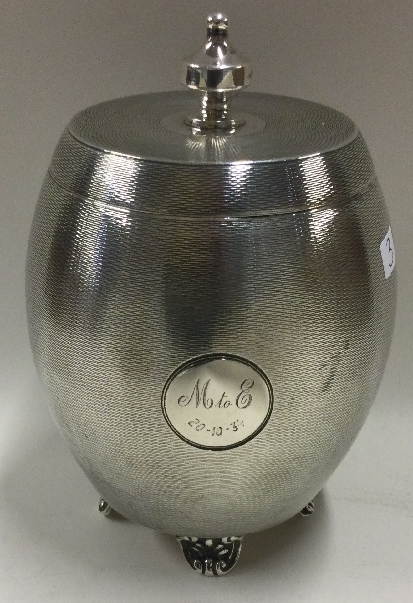 A heavy engine turned silver tea caddy with lift-off cover.